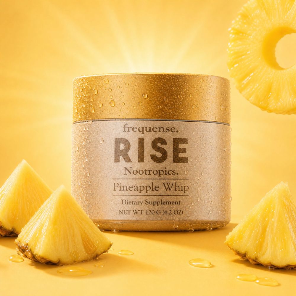 Frequense RISE Nootropics Pineapple Whip tub surrounded by fresh pineapple rings and wedges on a sunlit yellow field