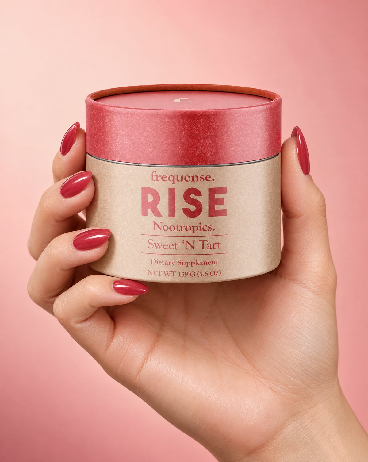 a hand holding the RISE Sweet 'N Tart jar against a pink backdrop