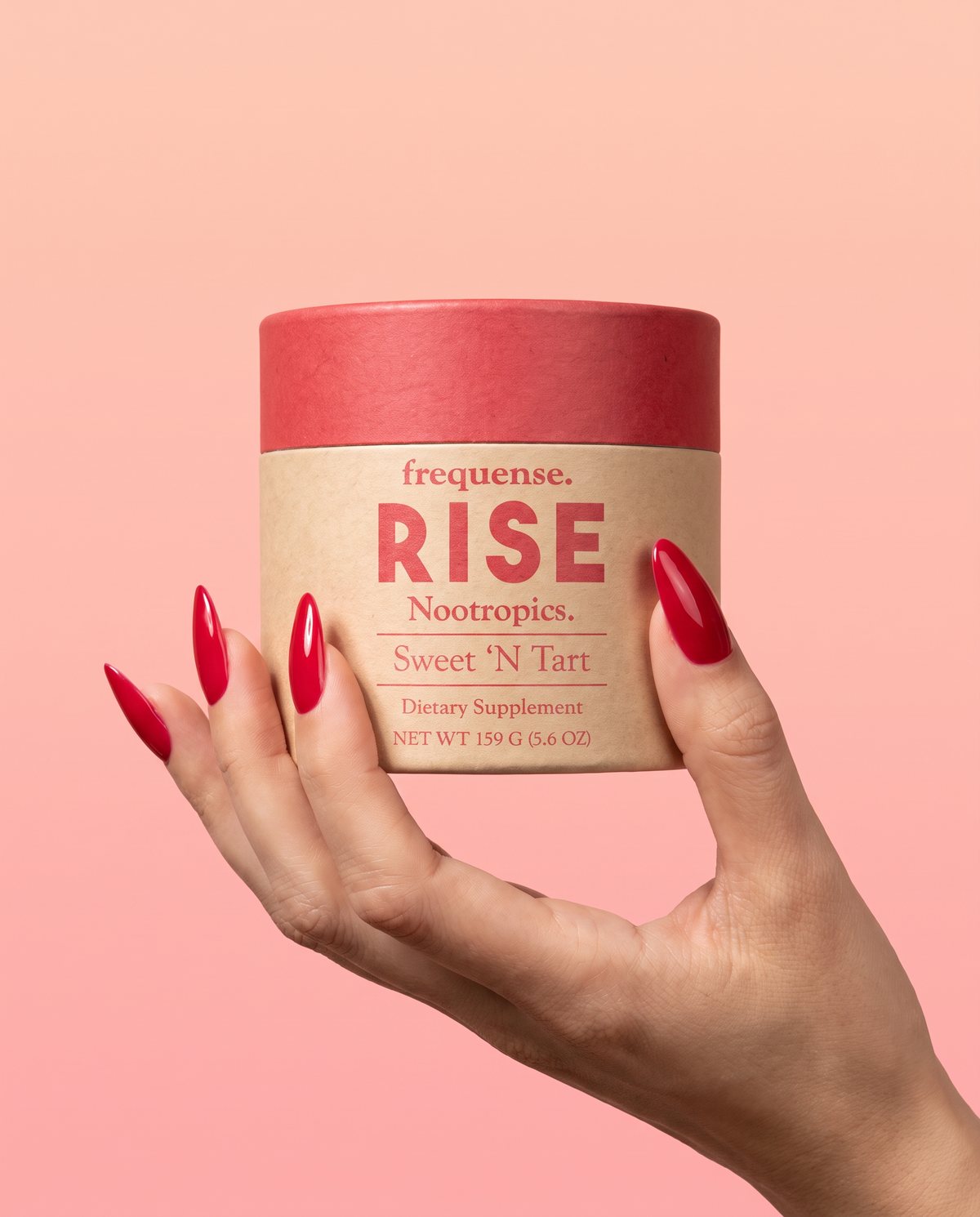 RISE Sweet 'N Tart jar held between fingertips against a peach backdrop.